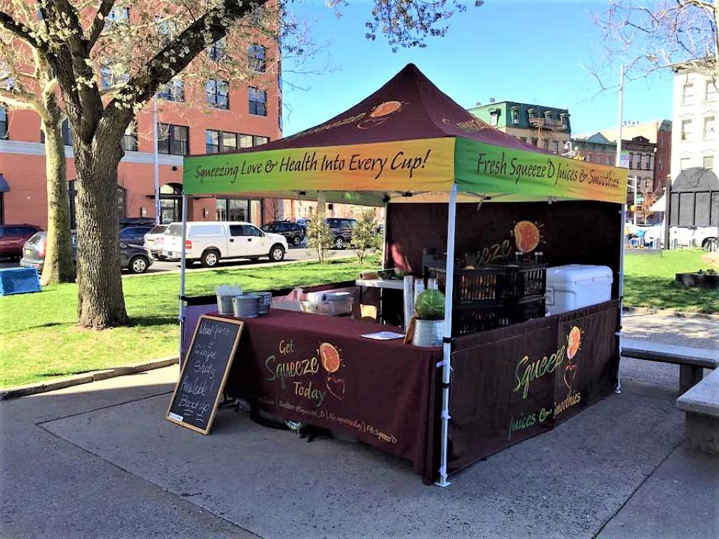 Coffee cart parked at bustling farmer’s market.